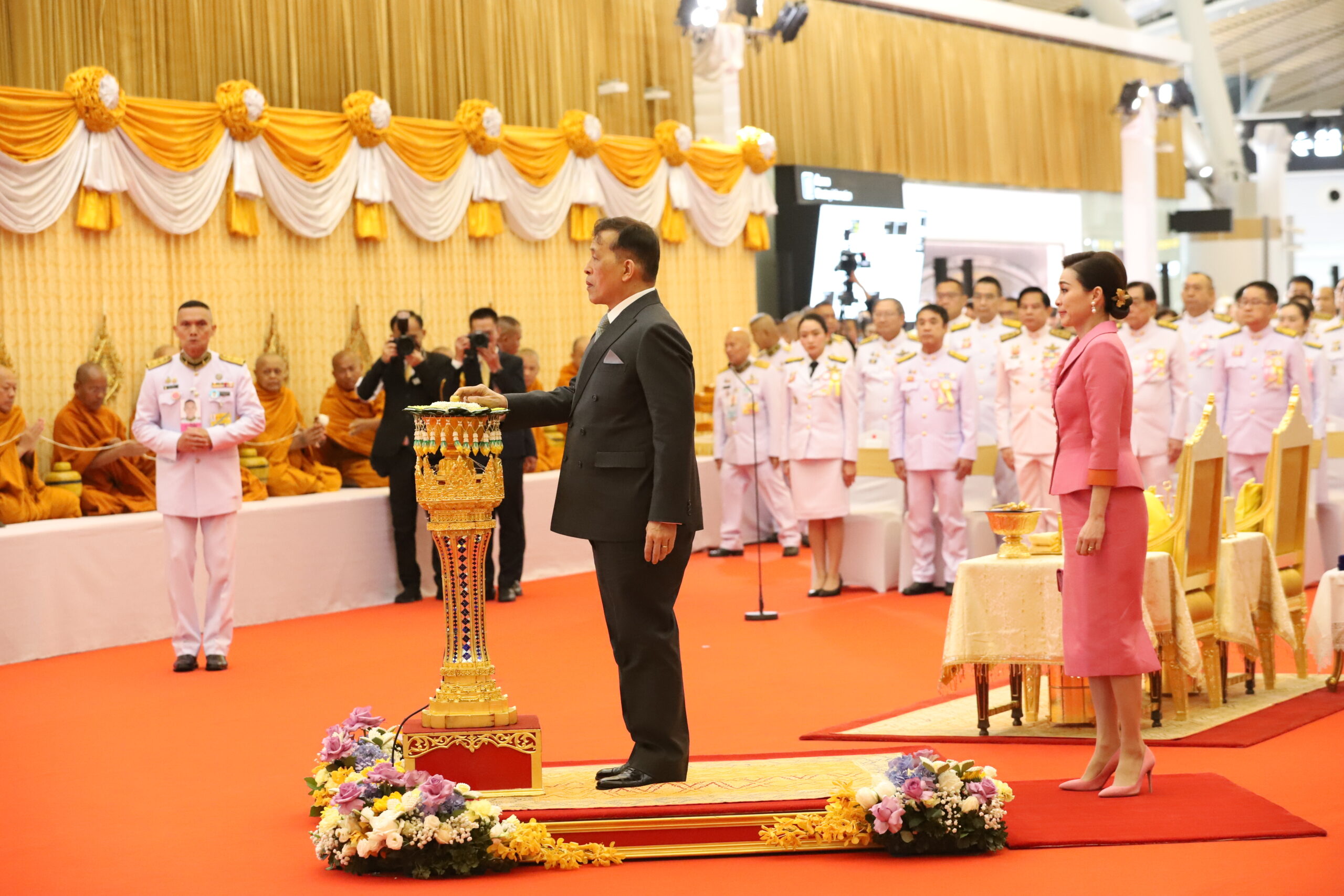 พระบาทสมเด็จพระเจ้าอยู่หัว และสมเด็จพระนางเจ้า ฯ พระบรมราชินี เสด็จพระราชดำเนินไปทรงเปิดอาคารเทียบเครื่องบินรองหลังที่ 1 และทางวิ่งเส้นที่ 3 ท่าอากาศยานสุวรรณภูมิ วันพฤหัสบดีที่ 20 มีนาคม 2568 เวลา 17.24 น. พระบาทสมเด็จพระเจ้าอยู่หัว และสมเด็จพระนางเจ้า ฯ พระบรมราชินี เสด็จพระราชดำเนินไปทรงเปิดอาคารเทียบเครื่องบินรองหลังที่ 1 และทางวิ่งเส้นที่ 3 ท่าอากาศยานสุวรรณภูมิ เนื่องในโอกาสพระราชพิธีมหามงคลเฉลิมพระชนมพรรษา 6 รอบ 28 กรกฎาคม 2567 ณ อาคารเทียบเครื่องบินรองหลังที่ 1 อำเภอบางพลี จังหวัดสมุทรปราการ โดยมี นางสาวแพทองธาร ชินวัตร นายกรัฐมนตรี นายสุริยะ จึงรุ่งเรืองกิจ รองนายกรัฐมนตรีและรัฐมนตรีว่าการกระทรวงคมนาคม นายศุภมิตร ชิณศรี ผู้ว่าราชการจังหวัดสมุทรปราการ นายชัยพรรษ เสริมสุวรรณ ผู้พิพากษาหัวหน้าคณะในศาลอุทธรณ์ช่วยทำงานชั่วคราว ในตำแหน่งอธิบดีผู้พิพากษาภาค 1 พลโทอมฤต บุญสุยา แม่ทัพภาคที่ 1 พลตำรวจโทสุรพล เปรมบุตร ผู้บัญชาการตำรวจภูธรภาค 1 นายกีรติ กิจมานะวัฒน์ กรรมการผู้อำนวยการใหญ่ บริษัท ท่าอากาศยานไทย จำกัด (มหาชน) และ นายกิตติพงศ์ กิตติขจร ผู้อำนวยการท่าอากาศยานสุวรรณภูมิ เฝ้าทูลละอองธุลีพระบาทรับเสด็จในการนี้ พระบาทสมเด็จพระเจ้าอยู่หัว และสมเด็จพระนางเจ้า ฯ พระบรมราชินี เสด็จพระราชดำเนินเข้าอาคารเทียบเครื่องบินรองหลังที่ 1 ชั้น G ประตู S101 ไปยังโถงผู้โดยสารขาออก ชั้น 3 และเสด็จเข้ามณฑลพิธี พระบาทสมเด็จพระเจ้าอยู่หัว ทรงจุดธูปเทียนเครื่องนมัสการบูชาพระพุทธนวราชบพิตร ทรงกราบ ทรงศีล ประธานสงฆ์ถวายศีล จบเสร็จแล้ว จากนั้น พระราชทานพระบรมราชวโรกาสให้ นางสาวแพทองธาร ชินวัตร นายกรัฐมนตรี เฝ้า ฯ ทูลเกล้า ฯ ถวายสูจิบัตรแด่พระบาทสมเด็จพระเจ้าอยู่หัว นายสุริยะ จึงรุ่งเรืองกิจ รองนายกรัฐมนตรี และรัฐมนตรีว่าการกระทรวงคมนาคม เฝ้า ฯ ทูลเกล้า ฯ ถวายสูจิบัตรแด่สมเด็จพระนางเจ้า ฯ พระบรมราชินี เสร็จแล้ว นางสาวแพทองธาร ชินวัตร นายกรัฐมนตรี กราบบังคมทูลรายงานความเป็นมา และวัตถุประสงค์ในการก่อสร้าง อาคารเทียบเครื่องบินรองหลังที่ 1 และทางวิ่งเส้นที่ 3 ท่าอากาศยานสุวรรณภูมิ จากนั้น พระบาทสมเด็จพระเจ้าอยู่หัว และสมเด็จพระนางเจ้า ฯ พระบรมราชินี เสด็จฯ ไปยังแท่นมณฑลพิธี พระบาทสมเด็จพระเจ้าอยู่หัวทรงกดปุ่มไฟฟ้าเปิดแพรคลุมป้าย “อาคารเทียบเครื่องบินรองหลังที่ 1” ทั้ง 2 ทิศทางของอาคาร พระสงฆ์เจริญชัยมงคลคาถา ชาวพนักงานลั่นฆ้องชัย ประโคมสังข์ แตร ดุริยางค์ เสร็จแล้ว เสด็จเข้ามณฑลพิธี ทรงประเคนจตุปัจจัยไทยธรรมถวายพระสงฆ์ ทรงหลั่งทักษิโณทก พระสงฆ์ถวายอนุโมทนา ถวายอดิเรก ทั้งนี้ พระบาทสมเด็จพระเจ้าอยู่หัว ทรงพระกรุณาโปรดเกล้าโปรดกระหม่อมพระราชทานพระบรมราชานุญาตให้เชิญตราสัญลักษณ์พระราชพิธีมหามงคลเฉลิมพระชนมพรรษา 6 รอบ 28 กรกฎาคม 2567 ประดิษฐานเหนือป้ายชื่ออาคารเทียบเครื่องบินรองหลังที่ 1 จากนั้นพระราชทานพระบรมราชวโรกาสให้ นายกีรติ กิจมานะวัฒน์ กรรมการผู้อำนวยการใหญ่ บริษัท ท่าอากาศยานไทย จำกัด (มหาชน) กราบบังคมทูลเบิกผู้ให้การสนับสนุนโครงการพัฒนาท่าอากาศยานสุวรรณภูมิ สำเร็จตามเป้าหมาย เฝ้ารับพระราชทานของที่ระลึก จำนวน 80 ราย เสร็จแล้ว พระราชทานพระบรมราชวโรกาสให้ นายชยธรรม์ พรหมศร ปลัดกระทรวงคมนาคม เฝ้าฯ ทูลเกล้า ฯ ถวายของที่ระลึกแด่พระบาทสมเด็จพระเจ้าอยู่หัว นายอภิรัฐ ไชยวงศ์น้อย ประธานกรรมการ บริษัท ท่าอากาศยานไทย จำกัด (มหาชน) เฝ้าฯ ทูลเกล้า ฯ ถวายของที่ระลึกแด่สมเด็จพระนางเจ้า ฯ พระบรมราชินี จากนั้น พระราชทานพระบรมราชวโรกาสให้ นายสุริยะ จึงรุ่งเรืองกิจ รองนายกรัฐมนตรีและรัฐมนตรี ว่าการกระทรวงคมนาคม เฝ้าฯ ทูลเกล้า ฯ ถวายเงินในนาม บริษัท ท่าอากาศยานไทย จำกัด (มหาชน) แด่พระบาทสมเด็จพระเจ้าอยู่หัวเพื่อโดยเสด็จพระราชกุศลตามพระราชอัธยาศัย เสร็จแล้ว นายกีรติ กิจมานะวัฒน์ กรรมการผู้อำนวยการใหญ่ บริษัท ท่าอากาศยานไทย จำกัด (มหาชน) เฝ้า ฯ ทูลเกล้า ฯ ถวายแผ่นศิลาเพื่อทรง ลงพระปรมาภิไธย จากนั้น พระบาทสมเด็จพระเจ้าอยู่หัวและสมเด็จพระนางเจ้า ฯ พระบรมราชินี ทรงลง พระปรมาภิไธย และทรงลงพระนามาภิไทยในแผ่นศิลา เสร็จแล้ว เสด็จฯ ไปทรงกราบที่หน้าเครื่องนมัสการ ทรงลาพระสงฆ์ เสด็จออกจากมณฑลพิธีไปยังห้องประทับรับรอง สมควรแก่เวลา เสด็จออกจากห้องรับรองที่ประทับไปยังบริเวณที่จัดนิทรรศการ ทอดพระเนตรนิทรรศการ “คมนาคมรวมใจ นำไทยสู่ศูนย์กลางการบิน” โดยกระทรวงคมนาคม ได้นำเสนอ นโยบายและโครงการพัฒนาโครงสร้างพื้นฐานด้านการคมนาคม ครอบคลุมทั้งทางบก ทางน้ำ ทางราง ทางอากาศ วิสัยทัศน์และพันธกิจในการยกระดับระบบคมนาคมของประเทศไทย จากนั้น ทรงทอดพระเนตร นิทรรศการของ บริษัท ท่าอากาศยานไทย จำกัด (มหาชน) ที่ได้บอกเล่าการดำเนินกิจการท่าอากาศยานไทยทั้งหมด 6 แห่ง ได้แก่ ท่าอากาศยานสุวรรณภูมิ ท่าอากาศยานดอนเมือง ท่าอากาศยานเชียงใหม่ ท่าอากาศยานหาดใหญ่ ท่าอากาศยานภูเก็ต และท่าอากาศยานแม่ฟ้าหลวง เชียงราย โครงการในพระราชดำริการระบายน้ำ ท่าอากาศยานสุวรรณภูมิ โดยพระบาทสมเด็จพระบรมชนกาธิเบศรมหาภูมิพล อดุลยเดชมหาราชบรมนาถบพิตร และได้ทอดพระเนตร แบบจำลองท่าอากาศยานสุวรรณภูมิเมื่อมีการพัฒนา เต็มรูปแบบ ต่อจากนั้นทรงทอดพระเนตรนิทรรศการของหน่วยงานที่เกี่ยวข้อง ได้แก่ สำนักงานการบินพลเรือนแห่งประเทศไทย ที่นำเสนอภาพรวมอุตสาหกรรมการบินของประเทศ และแผนโครงการส่งเสริมการเป็นศูนย์กลางการบิน นิทรรศการของ บริษัท วิทยุการบินแห่งประเทศไทย จำกัด นำเสนอเกี่ยวกับ พระราชกรณียกิจที่เกี่ยวเนื่อง กับการพัฒนาระบบการบินของประเทศ โครงการพัฒนาระบบเทคโนโลยีการบินและการจราจรทางอากาศ และนิทรรศการของ บริษัท การบินไทย จำกัด (มหาชน) ที่ได้จัดแสดง ให้เห็นถึง อัจฉริยะภาพด้านการบินของพระบาทสมเด็จพระเจ้าอยู่หัว และการดำเนินกิจการและแผนพัฒนาอุตสาหกรรมด้านการบิน นิทรรศการนี้ แสดงให้เห็นถึงความมุ่งมั่นของทุกภาคส่วนในการพัฒนาอุตสาหกรรรมการบินของประเทศไทยสู่การเป็นศูนย์กลางการบินที่สำคัญของภูมิภาค ในการ... ในการนี้ ทรงฉายพระบรมฉายาลักษณ์ร่วมกับนางสาวแพทองธาร ชินวัตร นายกรัฐมนตรี นายสุริยะ จึงรุ่งเรืองกิจ รองนายกรัฐมนตรีและรัฐมนตรีว่าการกระทรวงคมนาคม ผู้บริหารกระทรวงคมนาคม คณะกรรมการ และผู้บริหาร บริษัท ท่าอากาศยานไทย จำกัด (มหาชน) จำนวน 2 ชุด สมควรแก่เวลา จึงเสด็จ ฯ ออกจากอาคารเทียบเครื่องบินรองหลังที่ 1 ไปยังรถยนต์พระที่นั่ง โดยมี นางสาวแพทองธาร ชินวัตร นายกรัฐมนตรี พร้อมคณะ เฝ้าทูลละอองธุลีพระบาทส่งเสด็จ นายกีรติ กิจมานะวัฒน์ กรรมการผู้อำนวยการใหญ่ บริษัท ท่าอากาศยานไทย จำกัด (มหาชน) ได้กล่าวถึง การที่พระบาทสมเด็จพระเจ้าอยู่หัว และสมเด็จพระนางเจ้า ฯ พระบรมราชินี เสด็จพระราชดำเนินไปทรงเปิดอาคารเทียบเครื่องบินรองหลังที่ 1 และทางวิ่งเส้นที่ 3 ท่าอากาศยานสุวรรณภูมิ เนื่องในโอกาสพระราชพิธีมหามงคลเฉลิม พระชนมพรรษา 6 รอบ 28 กรกกฎาคม 2567 ณ อาคารเทียบเครื่องบินรองหลังที่ 1 ท่าอากาศยานสุวรรณภูมิ นั้น นับเป็นพระมหากรุณาธิคุณอย่างหาที่สุดมิได้ เป็นการสร้างขวัญและกำลังใจให้แก่ผู้บริหาร และพนักงาน บริษัท ท่าอากาศยานไทย จำกัด (มหาชน) รวมถึงทุกหน่วยงานที่เกี่ยวข้องในวันนี้ โดยเฉพาะการเปิดใช้อาคาร เทียบเครื่องบินรองหลังที่ 1 นับเป็นอีกหนึ่งก้าวสำคัญในการพัฒนาท่าอากาศยานสุวรรณภูมิให้มีความพร้อมในการรองรับการเติบโตของการเดินทางทางอากาศในอนาคต ความสำเร็จในครั้งนี้จะเป็นการขับเคลื่อนให้ทุกหน่วยงานที่เกี่ยวข้องกับอุตสาหกรรมการบิน มีความมุ่งมั่นในการพัฒนาโครงสร้างพื้นฐานทางการบินให้สอดคล้องกับความต้องการของการขยายตัวของการเดินทางและการท่องเที่ยวทั้งในประเทศและต่างประเทศ รวมถึงเป็นการส่งเสริมเศรษฐกิจของประเทศไทยให้เติบโตยิ่งขึ้นในอนาคต ท่าอากาศยานสุวรรณภูมิเป็นท่าอากาศยานหลักของประเทศ อยู่ภายใต้การกำกับดูแลและบริหารงาน โดย บริษัท ท่าอากาศยานไทย จำกัด (มหาชน) มีบทบาทสำคัญในการส่งเสริมและพัฒนาระบบคมนาคมขนส่ง ทางอากาศของประเทศให้เป็นหนึ่งในศูนย์กลางการบินของโลก เชื่อมโยงประเทศไทยกับจุดหมายปลายทางทั่วทุกมุมโลก นำมาซึ่งการเติบโตทางด้านเศรษฐกิจ การค้า การลงทุนและการท่องเที่ยวของประเทศอย่างต่อเนื่องมาโดยตลอด ท่าอากาศยานสุวรรณภูมิได้มีการริเริ่มดำเนินโครงการอย่างเป็นรูปธรรมในปี 2543 เมื่อพระบาทสมเด็จพระบรมชนกาธิเบศรมหาภูมิพล อดุลยเดชมหาราช บรมนาถบพิตร ทรงพระกรุณา โปรดเกล้าโปรดกระหม่อม พระราชทานชื่อ “ท่าอากาศยานสุวรรณภูมิ” ซึ่งมีความหมายว่า “แผ่นดินทอง” เมื่อวันที่ 29 กันยายน 2543 และทรงพระกรุณา โปรดเกล้าโปรดกระหม่อมเสด็จพระราชดำเนินทรงประกอบพิธีวางศิลาฤกษ์อาคารผู้โดยสาร ท่าอากาศยานสุวรรณภูมิ เมื่อเมื่อวันที่ 19 มกราคม 2545 ท่าอากาศยานสุวรรณภูมิได้เปิดให้บริการเชิงพาณิชย์ เมื่อวันที่ 28 กันยายน 2549 จากนั้นปีงบประมาณ 2554 - 2560 ทอท. ได้ดำเนินโครงการพัฒนาท่าอากาศยานสุวรรณภูมิ ระยะที่ 2 โดยได้มีการออกแบบและก่อสร้างอาคารเทียบเครื่องบินรองหลังที่ 1 แล้วเสร็จและเปิดให้บริการเมื่อเดือนกันยายน 2566 ที่ผ่านมา โดยตัวอาคารมีความสูง 4 ชั้น และมีชั้นใต้ดิน 2 ชั้น รวมมีพื้นที่ใช้สอยทั้งหมดประมาณ 216,000 ตารางเมตร มีหลุมจอดประชิดอาคารทั้งหมด 28 หลุมจอด สำหรับการตกแต่งภายในของอาคาร SAT-1 มีการออกแบบให้เข้ากับอาคารผู้โดยสารหลักเช่นกัน แต่ได้มีการผสมผสานระหว่างสถาปัตยกรรม ศิลปะที่สะท้อนเอกลักษณ์ความเป็นไทยให้กลมกลืนไปกับโครงสร้างอาคารที่ทันสมัย โดยมีผลงานการตกแต่งชิ้นเอกเป็น ของ... ช้างคชสาร ตั้งอยู่บริเวณโถงกลางของชั้น 3 ซึ่งเป็นพื้นที่สำหรับผู้โดยสารขาออก ส่วนปลายอาคารทั้ง 2 ด้านคือ ทิศตะวันออกและทิศตะวันตกติดตั้งสุวรรณบุษบก และ รัตนบุษบก ซึ่งเป็นที่ประดิษฐานองค์พระพุทธปฏิมา ปางมารวิชัย และ ปางเปิดโลก โดยถอดแบบมาจากวัดผาซ่อนแก้ว เพื่อความเป็นสิริมงคลต่อสถานที่ เป็นขวัญและกำลังใจต่อผู้ปฏิบัติงานและผู้เดินทาง ภายในชั้น 3 ของอาคารได้รับการออกแบบให้เป็นสวน ตกแต่งด้วยสัตว์หิมพานต์ ตามคติความเชื่อไทยแต่โบราณ อาทิ กินนร กินรี เหมราช และหงส์สา โดยผลของความประณีตในการออกแบบตกแต่งดังกล่าว ได้ส่งผลให้คณะกรรมการ The Versailles Selection Committee ร่วมกับองค์การศึกษา วิทยาศาสตร์ และวัฒนธรรมแห่งสหประชาชาติ ได้คัดเลือกให้อาคารเทียบเครื่องบินรองหลังที่ 1 ของท่าอากาศยานสุวรรณภูมิ ติดอันดับ 1 ใน 6 สนามบินที่สวยที่สุดในโลก ประจำปี 2567 (The World’s most beautiful List 2024) และ ได้มอบรางวัล Prix Versailles ประจำปี 2024 สาขาสถาปัตยกรรมดีเด่นด้านรูปลักษณ์อาคาร (Exterior) ให้แก่ บริษัท ท่าอากาศยานไทย จำกัด (มหาชน) เมื่อวันที่ 4 ธันวาคม 2567 ณ สำนักงานใหญ่ยูเนสโก (UNESCO) กรุงปารีส สาธารณรัฐฝรั่งเศส การเปิดให้บริการอาคารเทียบเครื่องบินรองหลังที่ 1 ในครั้งนี้ นับเป็นอีกหนึ่งก้าวสำคัญที่ช่วยเพิ่มศักยภาพในการรองรับผู้โดยสารของท่าอากาศยานสุวรรณภูมิ จากเดิม 45 ล้านคนเป็น 60 ล้านคนต่อปี สำหรับทางวิ่งเส้นที่ 3 เป็นทางวิ่งที่มีความยาว 4,000 เมตร กว้าง 60 เมตร ตั้งอยู่ทางด้านทิศตะวันตกของท่าอากาศยาน ขนานกับทางวิ่ง เส้นที่ 1 เปิดใช้งานเมื่อช่วงเดือนตุลาคม 2567 โดยได้เพิ่มศักยภาพในการรองรับเที่ยวบินของท่าอากาศยานสุวรรณภูมิจากเดิมที่ 68 เที่ยวบินต่อชั่วโมง เป็น 94 เที่ยวบินต่อชั่วโมง หรือเฉลี่ยประมาณ 800 - 1,000 เที่ยวบินต่อวัน เพิ่มขีดความสามารถในการแข่งขันกับท่าอากาศยานชั้นนำระดับโลก บริษัท ท่าอากาศยานไทย จำกัด (มหาชน) พร้อมที่จะมุ่งมั่นพัฒนา ยกระดับมาตรฐานการให้บริการท่าอากาศยานสุวรรณภูมิให้ก้าวเป็นท่าอากาศยานดีเด่นติดอันดับโลก และเป็นกลไกลสำคัญในการส่งเสริมการเป็นศูนย์กลางการบินระดับภูมิภาคและระดับโลก (Aviation Hub) ตามนโยบายของรัฐบาล ในการสนับสนุนการเติบโตด้านเศรษฐกิจการค้า การลงทุน และการท่องเที่ยวของประเทศอย่างยิ่งยืนในระยะยาวต่อไป