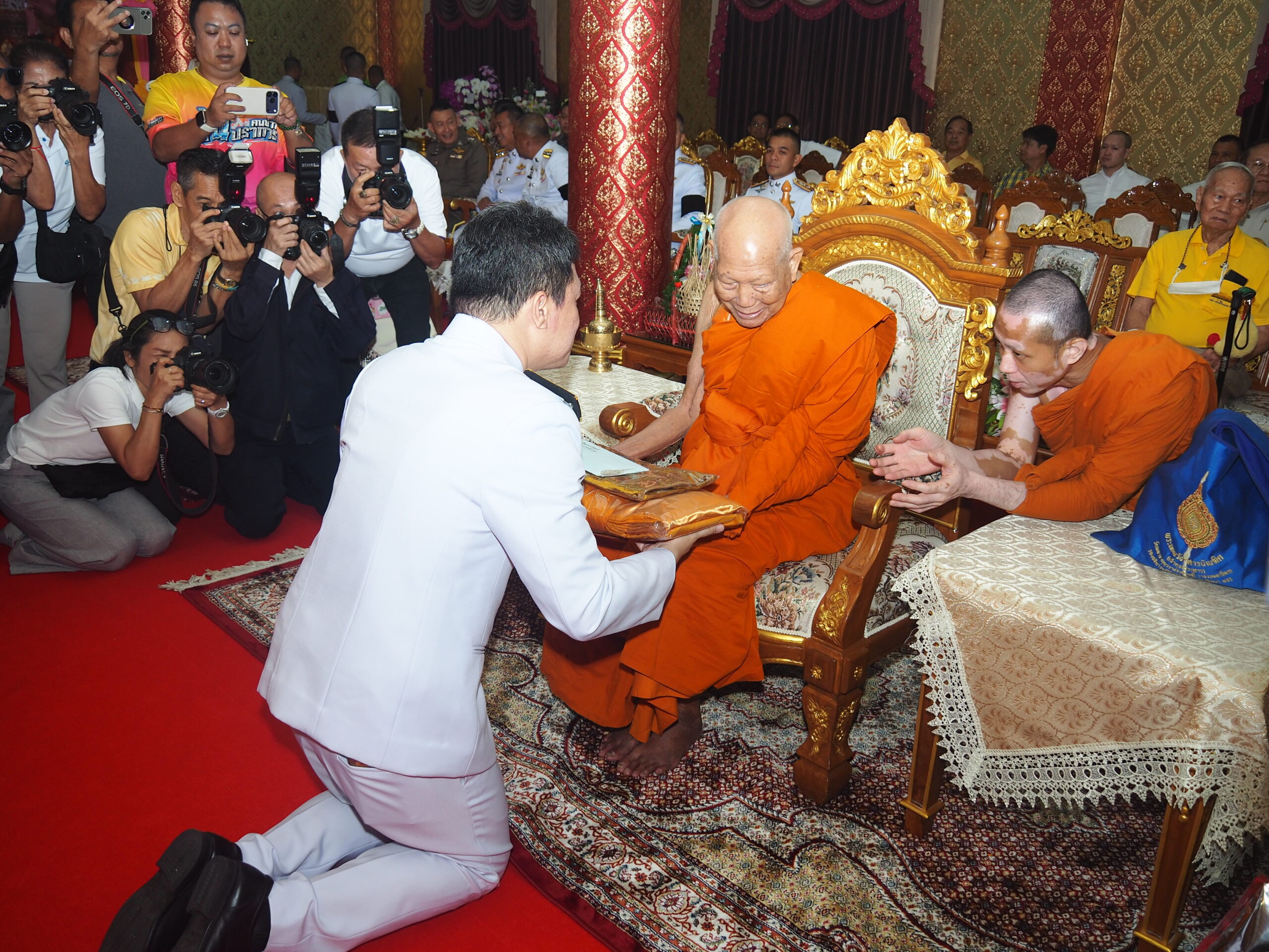 สมุทรปราการ-พระบาทสมเด็จพระเจ้าอยู่หัว ทรงพระกรุณาโปรดเกล้าฯ พระราชทานผ้าไตรในพิธีทำบุญอายุวัฒนมงคล 64 ปี พระวชิรคณาทร พระบาทสมเด็จพระเจ้าอยู่หัว ทรงพระกรุณาโปรดเกล้าฯ พระราชทานผ้าไตร และเครื่องสังฆทานพระราชทานเพื่อถวายแด่พระราชาคณะ จำนวน 1 รูป วันเสาร์ที่ 18 เมษายน 2569 เวลา 10.00 น. พระบาทสมเด็จพระเจ้าอยู่หัว ทรงพระกรุณาโปรดเกล้าฯ ให้ พลเรือตรีสกาย เภกะนันทน์ หัวหน้าส่วนราชการพระตำหนักราชฤทธิ์รุ่งโรจน์ ปิยนาฎวชิรพัทธ์ เป็นประธานในพิธีเชิญผ้าไตรพระราชทาน และเครื่องสังฆทานพระราชทาน เพื่อถวายแด่พระราชาคณะ จำนวน 1 รูป ในพิธีทำบุญอายุวัฒนมงคล 64 ปี พระวชิรคณาทร หรือที่พุทธศาสนิกชนรู้จักในนาม เจ้าคุณแจ้ วัดบางพลีใหญ่กลาง ตำบลบางพลีใหญ่ อำเภอบางพลี จังหวัดสมุทรปราการ โดยมี นายขจิตเวช แก้วน้อย นายอำเภอบางพลี หัวหน้าส่วนราชการ ผู้นำท้องถิ่น ผู้อำนวยการโรงพยาบาล ผู้อำนวยการสถานศึกษา เจ้าหน้าที่สำนักพุทธศาสนาจังหวัดสมุทรปราการ คณะแพทย์พยาบาล ข้าราชการตำรวจ ประชาชน และคณะสงฆ์ทรงสมณศักดิ์เข้าร่วมพิธี และกราบถวายมุทิตาสักการะเจริญอายุวัฒนมงคลครบ 64 ปี พระวชิรคณาทร หรือท่านเจ้าคุณแจ้ เจ้าอาวาสวัดบางพลีใหญ่กลาง จากนั้น ประธานในพิธีจุดธูปเทียนเครื่องนมัสการบูชาพระ ถวายความเคารพพระบรมฉายาลักษณ์สมเด็จพระเจ้าอยู่หัว กล่าวคำถวายสังฆทาน ประเคนเครื่องสังฆทานพระราชทาน ถวายแด่พระวชิรคณาทร เจ้าอาวาสวัดบางพลีใหญ่กลาง ในพิธีได้รับความเมตตาจาก พระพรหมวชิราธิบดี (พีร์ สุชาโต) อธิบดีสงฆ์วัดมหาธาตุยุวราชรังสฤษฎิ์ราชวรมหาวิหาร ที่ปรึกษาเจ้าคณะกรุงเทพมหานคร พร้อมด้วย พระพรหมดิลก พระราชาคณะเจ้าคณะรอง อดีตกรรมการมหาเถรสมาคม เจ้าอาวาสวัดสามพระยา วรวิหาร กรุงเทพมหานคร รวมทั้งพระเกจิและพระเถรานุเถระและพระสงฆ์ทรงสมณศักดิ์ ร่วมเจริญชัยมงคลคาถากราบถวายมุทิตาสักการะ เจริญอายุวัฒนมงคล ครบ 64 ปี พระวชิรคณาทร เจ้าอาวาสวัดบางพลีใหญ่กลาง พระวชิรคณาทร เป็นพระนักพัฒนาและเป็นพระที่เสียสละที่อุทิศตนปฏิบัติศาสนกิจ เผยแพร่หลักธรรมคำสอน เพื่อสืบต่ออายุพระพุทธศาสนา และแสดงเมตตาธรรมแก่สังคม โดยได้มอบเงินสนับสนุนสร้างอาคารเรียน สร้างโรงพยาบาล ส่งเสริมด้านการศึกษา ภารกิจช่วยเหลือดูแลสังคมและดูแลประชาชน รวมถึงการสงเคราะห์เผาศพผู้ยากไร้ฟรีไม่มีค่าใช้จ่าย